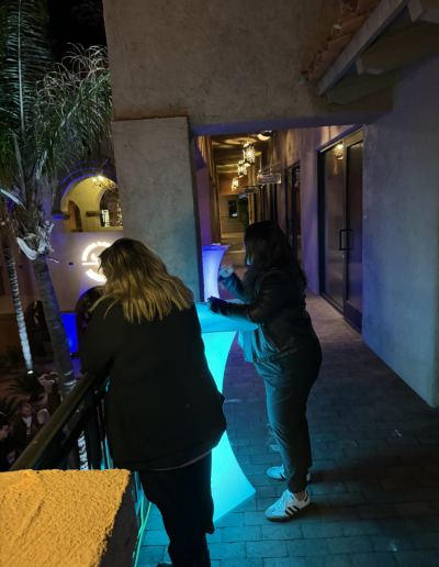 people standing at tall illuminated table