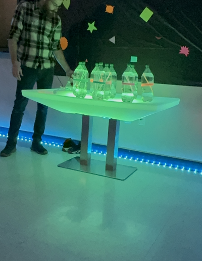 table illuminated with water bottles on top.