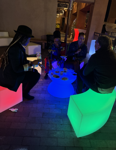 illuminated table and lounge set being used by party guests